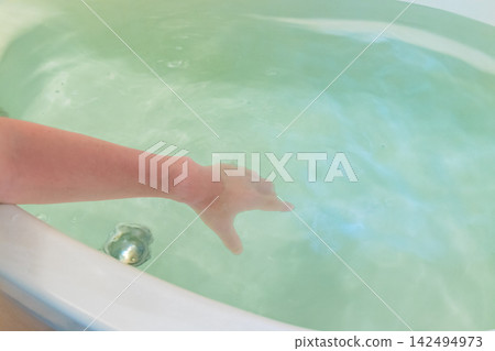 Stir the bathwater with your hands. Stir the bathwater with your hands. 142494973
