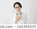 一位中年婦女在白色背景下使用智慧型手機思考。 142495035