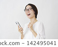 一位中年婦女拿著智慧型手機，突然想到一個主意（白色背景）。 142495041