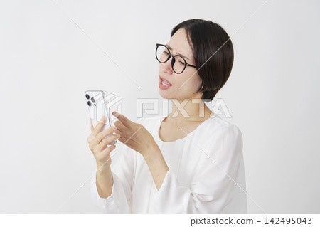 中年婦女看著手機，顯得很生氣（白色背景） 142495043