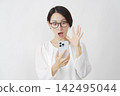 一位中年婦女在白色背景下驚訝地看著她的智慧型手機。 142495044
