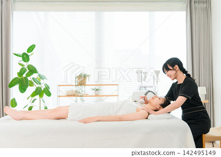 一位女美容師正在使用美容儀器進行頸部和胸部護理。 一位女美容師正在使用美容儀器進行頸部和胸部護理。 142495149