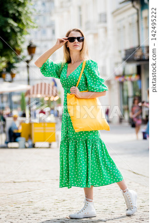 Young beautyful woman with yellow linen eco bag on city background. Young beautyful woman with yellow linen eco bag on city background. 142495222