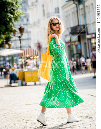 Young beautyful woman with yellow linen eco bag on city background. 142495231