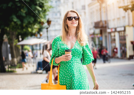 Young beautyful woman with yellow linen eco bag on city background. Young beautyful woman with yellow linen eco bag on city background. 142495235