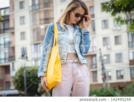 Young beautiful woman with linen eco bag on city background. Young beautiful woman with linen eco bag on city background. 142495249