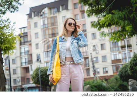 Young beautiful woman with linen eco bag on city background. 142495250