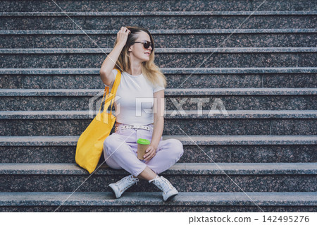 Young beautiful woman with linen eco bag on stairs background. Young beautiful woman with linen eco bag on stairs background. 142495276