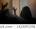 Christians raising their hands to passionately worship, praise, and pray; a Spirit-filled gathering background 142495398
