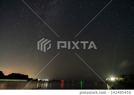 夜空中的銀河和海面上反射的人造光。 142495458