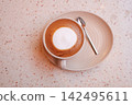 Coffee served in a cup on a plate with a spoon 142495611