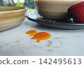 Food sauce spills on a table near bowls and plates 142495613