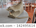 Handbag resting on a table in a cafe setting 142495614