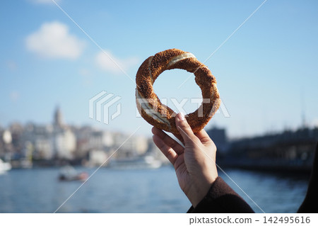 Holding a turkish simits near the water in Istanbul 142495616