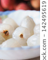 peeled lychee fruit with a translucent white flesh and a small brown seed core  142495619