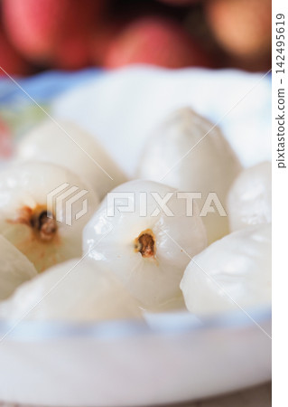 peeled lychee fruit with a translucent white flesh and a small brown seed core peeled lychee fruit with a translucent white flesh and a small brown seed core 142495619