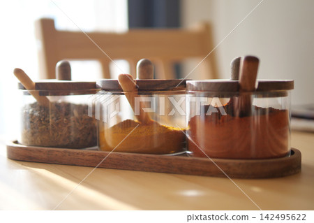 Colorful spice jars on a kitchen table 142495622
