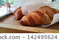 Croissants served on a wooden tray at a cafe 142495624