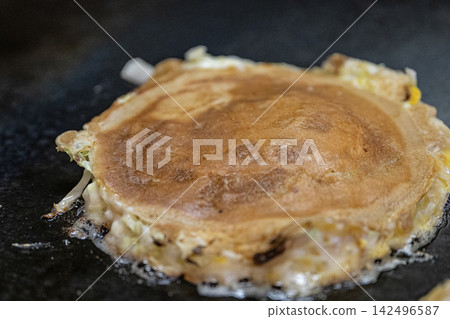 The surface of the okonomiyaki, which is nicely browned. The surface of the okonomiyaki, which is nicely browned. 142496587