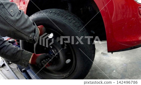 汽車修理工正在拆解汽車輪胎 汽車修理工正在拆解汽車輪胎 142496786