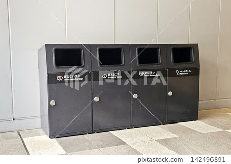 Row of dark gray recycling bins for sorting waste in public space. Row of dark gray recycling bins for sorting waste in public space. 142496891
