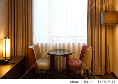 Table and chairs by the window in a luxury hotel room Table and chairs by the window in a luxury hotel room 142497055