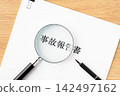 Close-up of the accident report, magnifying glass, and ballpoint pen. 142497162