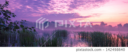Magical purple sunrise over the lake. Misty morning, rural landscape, wilderness Magical purple sunrise over the lake. Misty morning, rural landscape, wilderness 142498640