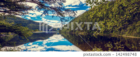 Rocky shore of the mountain lake in an autumn morning. Beautiful nature of Norway. Reflection of the sky in the lake Rocky shore of the mountain lake in an autumn morning. Beautiful nature of Norway. Reflection of the sky in the lake 142498748