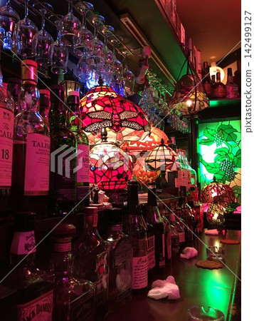一家威士忌酒吧,四周環繞著彩色玻璃燈。 一家威士忌酒吧,四周環繞著彩色玻璃燈。 142499127
