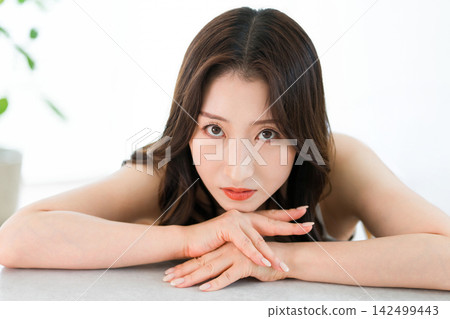 A portrait of a woman gazing at the camera with a cool expression. A portrait of a woman gazing at the camera with a cool expression. 142499443