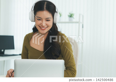 Young Asian Woman Studying Online with Laptop, Tablet, Smartphone and Headphones at Home, Adult Education and E-Learning Young Asian Woman Studying Online with Laptop, Tablet, Smartphone and Headphones at Home, Adult Education and E-Learning 142500486