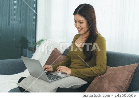 Young Asian Woman Studying Online with Laptop, Tablet, Smartphone and Headphones at Home, Adult Education and E-Learning Young Asian Woman Studying Online with Laptop, Tablet, Smartphone and Headphones at Home, Adult Education and E-Learning 142500509