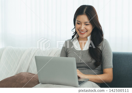Young Asian Woman Studying Online with Laptop, Tablet, Smartphone and Headphones at Home, Adult Education and E-Learning Young Asian Woman Studying Online with Laptop, Tablet, Smartphone and Headphones at Home, Adult Education and E-Learning 142500511