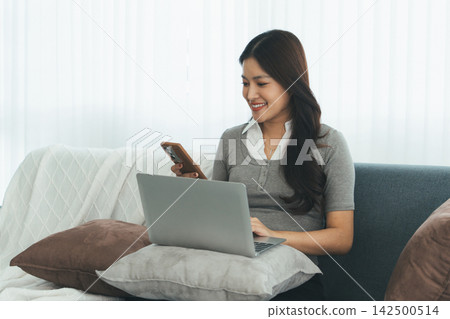 Young Asian Woman Studying Online with Laptop, Tablet, Smartphone and Headphones at Home, Adult Education and E-Learning Young Asian Woman Studying Online with Laptop, Tablet, Smartphone and Headphones at Home, Adult Education and E-Learning 142500514