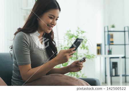 Young Asian Woman Studying Online with Laptop, Tablet, Smartphone and Headphones at Home, Adult Education and E-Learning Young Asian Woman Studying Online with Laptop, Tablet, Smartphone and Headphones at Home, Adult Education and E-Learning 142500522