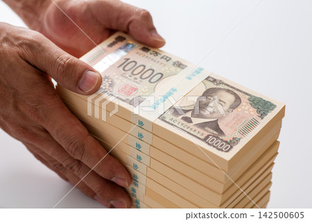 一名男子的雙手拿著一疊1000萬日元現金。 一名男子的雙手拿著一疊1000萬日元現金。 142500605
