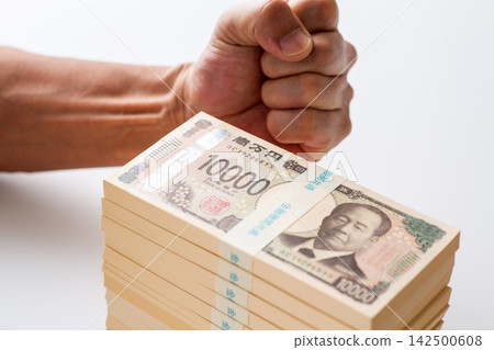 一名男子雙手捧著一疊1000萬日圓現金,擺出勝利的姿勢。 一名男子雙手捧著一疊1000萬日圓現金,擺出勝利的姿勢。 142500608