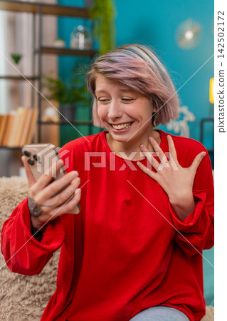 Young woman celebrating victory in online mobile game, expressing excited surprise joyful emotions Young woman celebrating victory in online mobile game, expressing excited surprise joyful emotions 142502172
