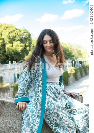 Elegant woman looking down thoughtfully in natural light outdoors Elegant woman looking down thoughtfully in natural light outdoors 142502402