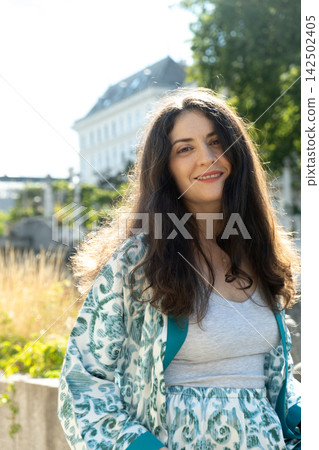 Happy adult female looking at camera with long hair outdoors Happy adult female looking at camera with long hair outdoors 142502405