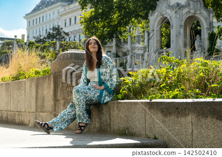Happy adult female enjoying sunny day outdoors with historic architecture background. Happy adult female enjoying sunny day outdoors with historic architecture background. 142502410