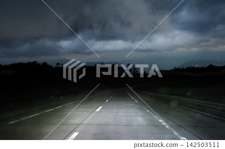 dark night road through forest and mountains, rain and storm, bad weather concept 142503511