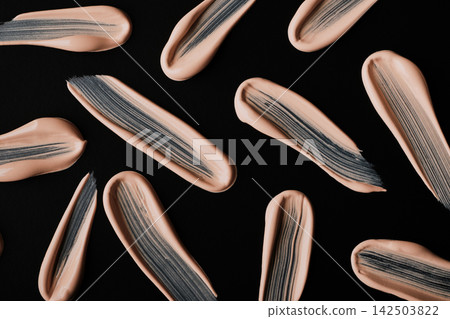 Liquid foundation makeup strokes on black background showing cosmetics pattern Liquid foundation makeup strokes on black background showing cosmetics pattern 142503822