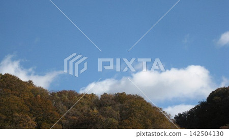 Blue sky, white clouds, and mountains with autumn foliage. Blue sky, white clouds, and mountains with autumn foliage. 142504130
