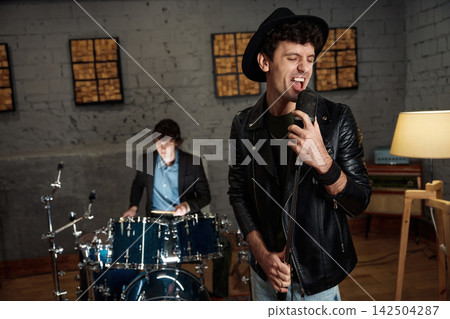 Rock band practicing with intense emotion and vintage style atmosphere Rock band practicing with intense emotion and vintage style atmosphere 142504287