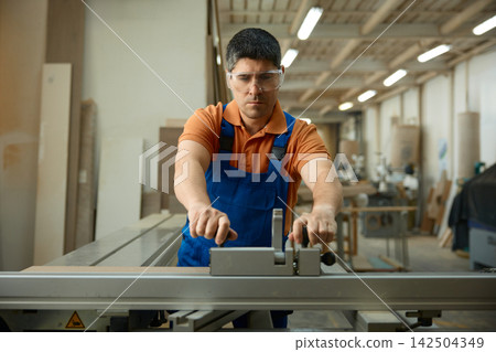 Craftsman carefully operates cutting devices to ensure flawless results safely Craftsman carefully operates cutting devices to ensure flawless results safely 142504349