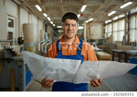 Plant supervisor evaluates production schematics and safety procedures diligently 142504353