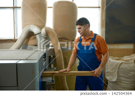 Craftsman applying detailed finishing on wood panel carefully 142504364