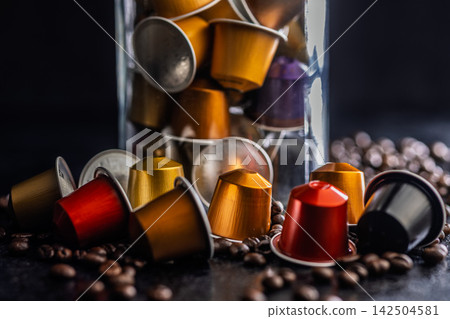 Colorful Espresso Coffee Pods And Roasted Coffee Beans In Glass Jar On Dark Table Colorful Espresso Coffee Pods And Roasted Coffee Beans In Glass Jar On Dark Table 142504581
